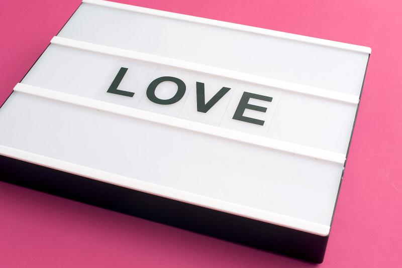 Free Stock Photo: Changeable sign LOVE on white table box laying on pink background surface