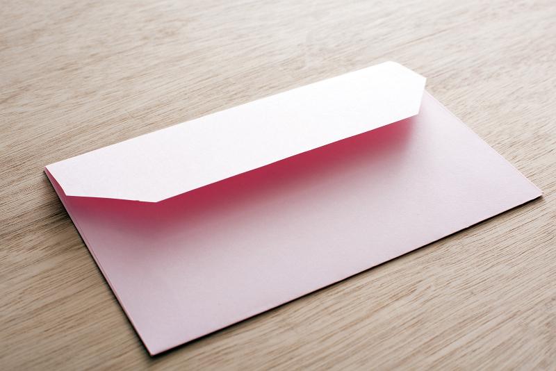 Free Stock Photo: Pink blank Valentines card envelope close-up over wooden table surface