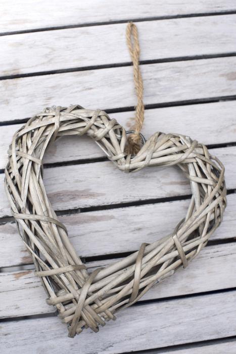 Free Stock Photo: Wicker heart shaped decoration on a string, close-up on wooden boards of table surface