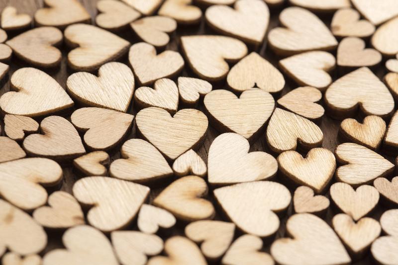 Free Stock Photo: Scattered wooden hearts Valentines background arranged in a random pattern of different sizes viewed obliquely with shallow dof