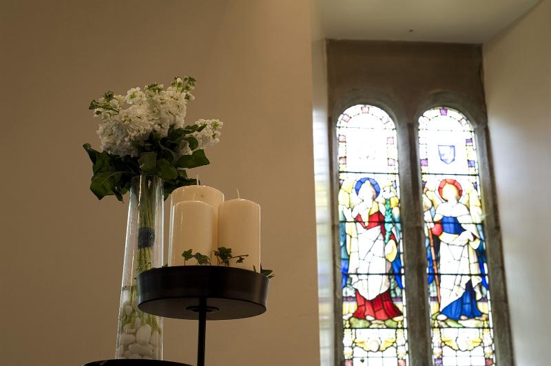 Free Stock Photo: a stained glass window and a decorative stand with candles and flowers