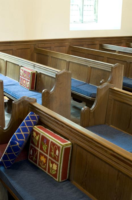 Free Stock Photo: rows of old wooden church pews with prayer cushions
