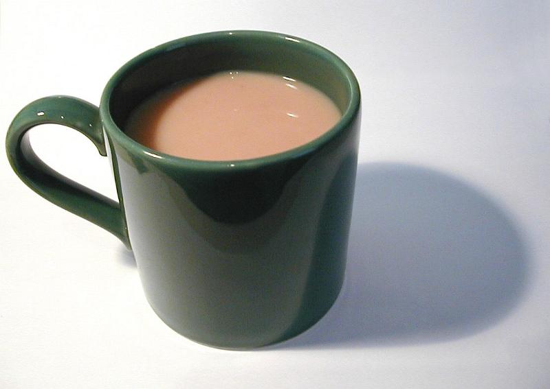 Free Stock Photo: Close-up of a green porcelain mug full of hot coffee with milk, with shadow, on grey