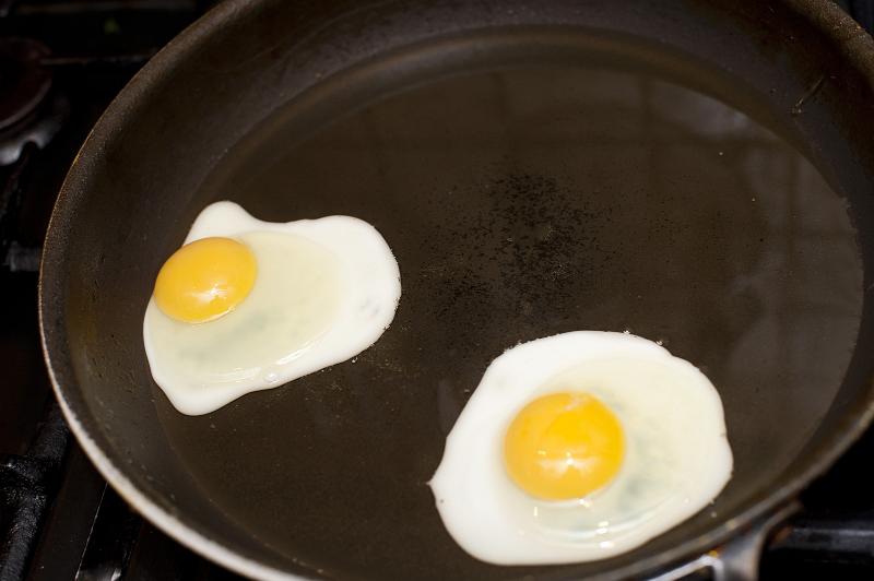 Free Stock Photo: Two fried eggs with rich yellow yolks in a non-stick frying pan ready to serve for breakfast