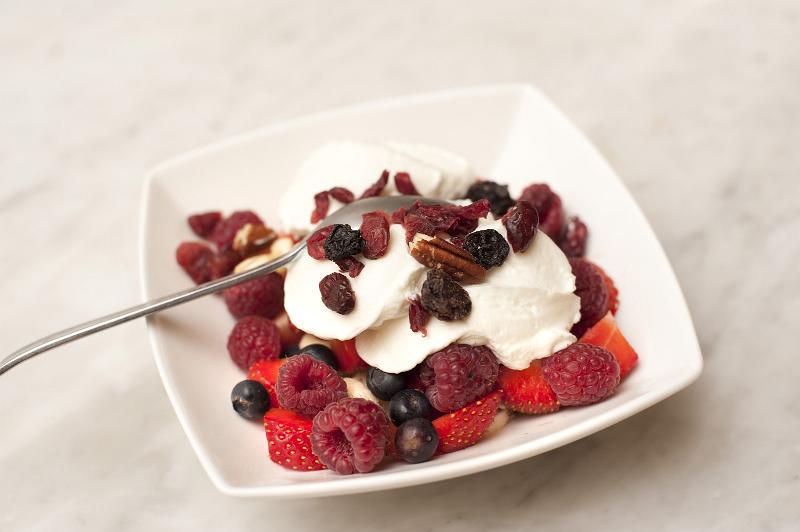 Free Stock Photo: Healthy fruit breakfast with a bowl of raisins, strawberries, raspberries and blueberries served with thick creamy yoghurt