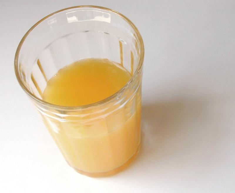 Free Stock Photo: High angle view of a tall half drunk glass of fresh orange juice for a healthy breakfast rich in vitamin c on a white background with copyspace