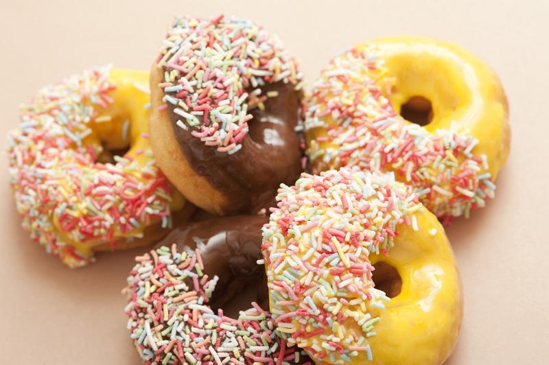 Free Stock Photo: Assorted ring doughnuts with sprinkles and chocolate or orange icing in a random pile ready for a delicious coffee break