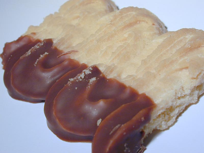 Free Stock Photo: Crunchy pastry biscuit dipped in chocolate on the one side , close up view of the chocolate end on white