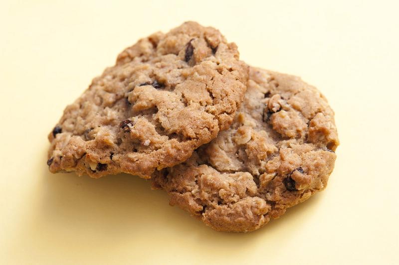 Free Stock Photo: Two tasty fresh crunchy country biscuits on a yellow background ready for a teatime snack