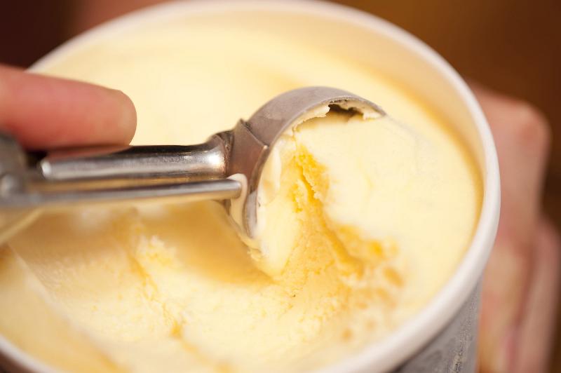 Free Stock Photo: Man serving tasty creamy vanilla Ice cream in a bowl with a metal scoop, close up view