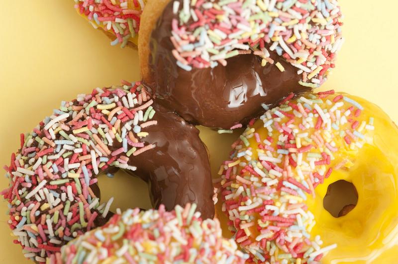 Free Stock Photo: Orange and chocolate glazed ring doughnuts or donuts dipped in multicolored sprinkles for a tasty coffee break or dessert