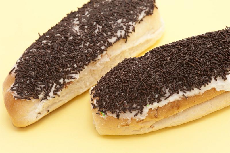Free Stock Photo: Two tasty sticky iced buns decorated with chocolate sprinkles viewed close up over a pale yellow background