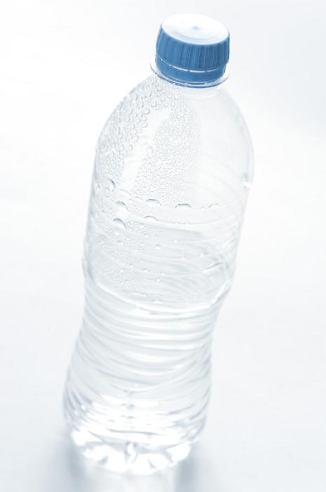 Free Stock Photo: Plastic bottle of cold fresh pure mineral water with beaded condensation on the surface and a blue cap, unlabeled on white