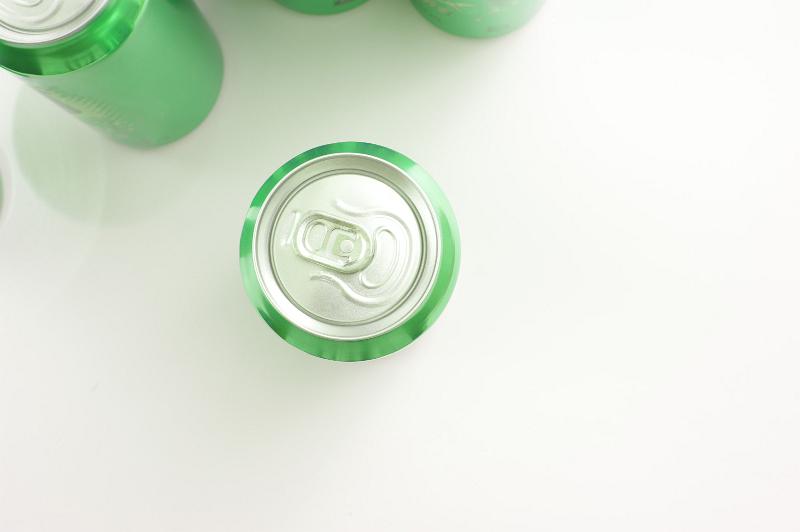 Free Stock Photo: Sealed aluminium can for soda or an energy drink viewed from overhead on white with copyspace and additional green cans visible to the side