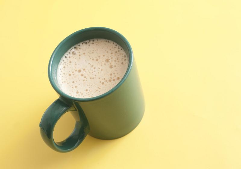 Free Stock Photo: Green mug of vanilla cappuccino or cafe latte, high-angle close-up on yellow