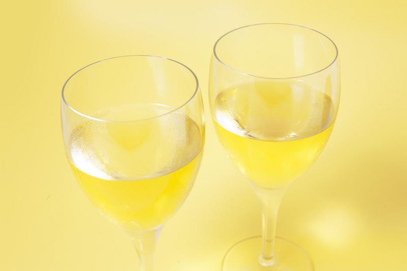 Free Stock Photo: Two glasses of white chardonnay wine viewed high angle closeup over a yellow background