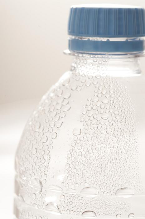 Free Stock Photo: Plastic bottle of cold water with beaded condensation and effervescence closed with a blue cap, close up detail of the shoulder and neck of the bottle