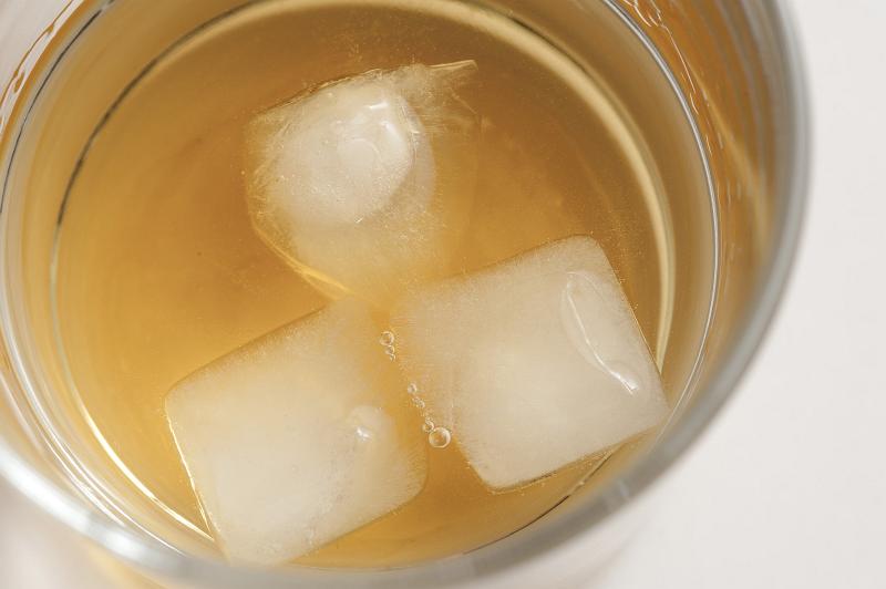 Free Stock Photo: Iced tot measure of whiskey on the rocks in a glass tumbler, close up view of the beverage and ice cubes from above