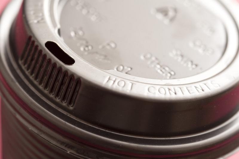 Free Stock Photo: Detail of the lid of a plastic takeaway coffee cup viewed at an angle to enhance the text - hot contents - on the rim