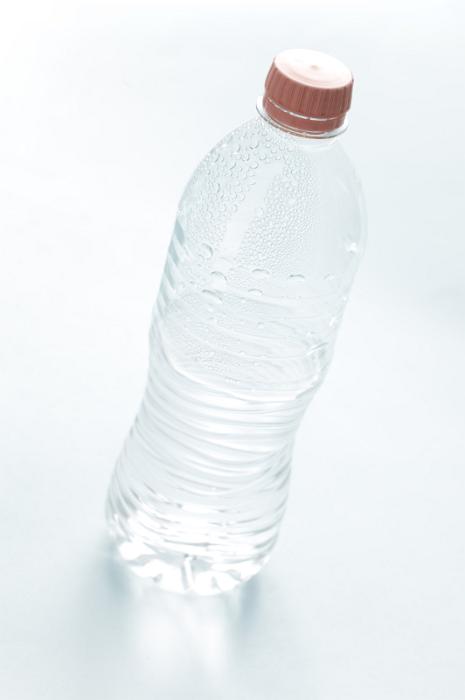 Free Stock Photo: Pure water in an unlabeled closed plastic bottle, tilted high angle view on white