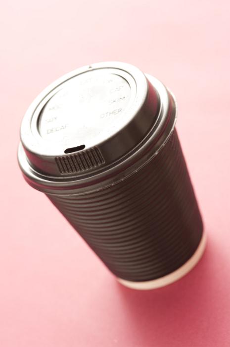 Free Stock Photo: Disposable plastic mug of takeaway coffee or hot beverage with a closed lid viewed high angle on a pink background