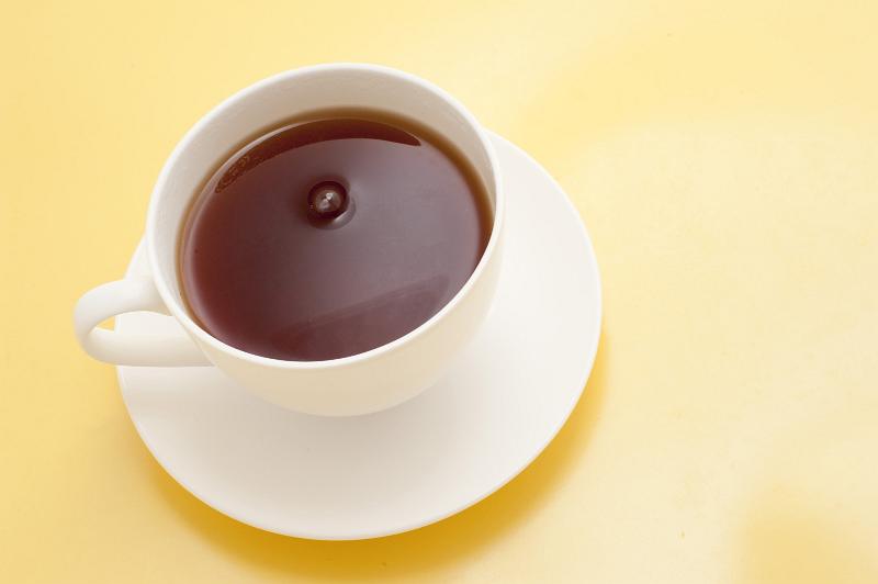 Free Stock Photo: Freshly brewed cup of hot black tea for a relaxing tea break viewed high angle on a yellow background with copyspace