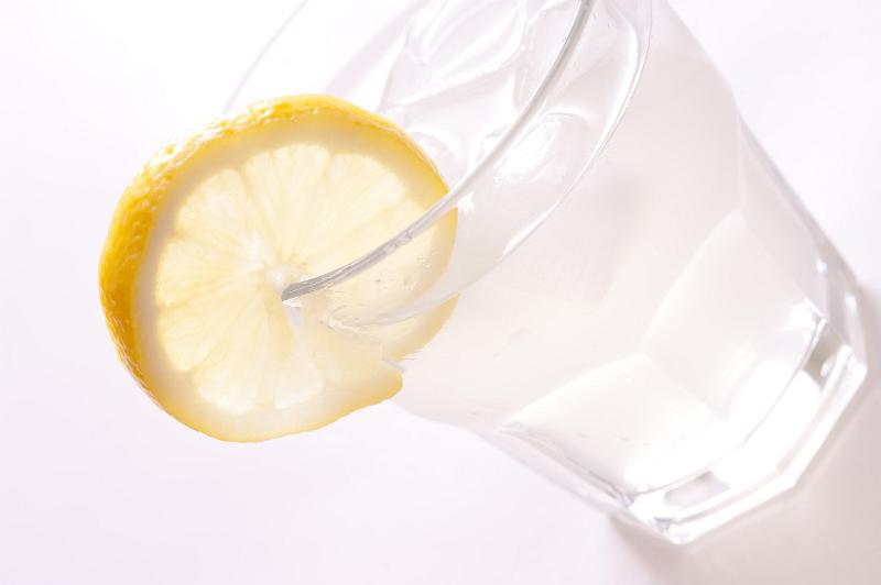 Free Stock Photo: Angled view of a cold glass of gin and tonic garnished with a slice of fresh lemon served with ice