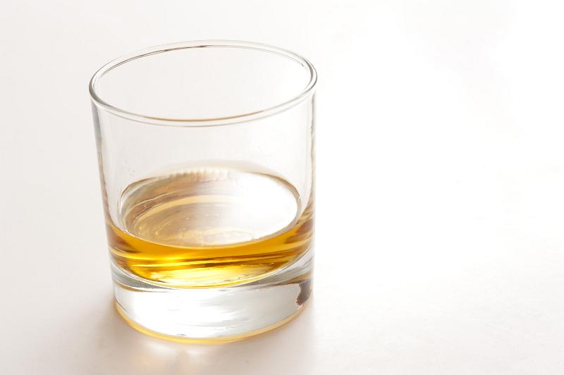 Free Stock Photo: Whiskey or scotch in a glass tumbler served neat without ice on a white background with copyspace