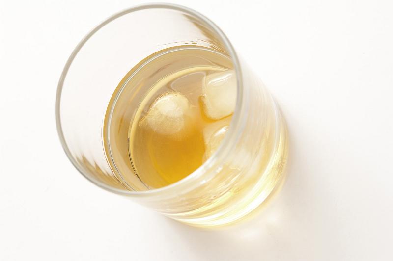 Free Stock Photo: Glass of whiskey or scotch on the rocks viewed high angle showing the golden liquor and ice cubes on a white background