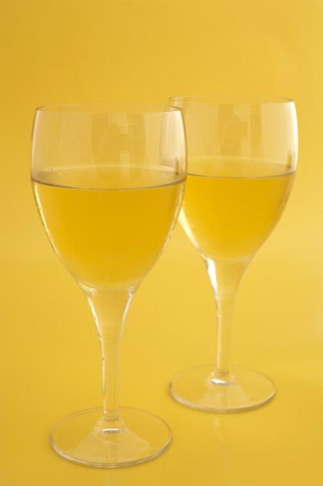 Free Stock Photo: Two wineglasses of white wine standing side by side on a yellow background