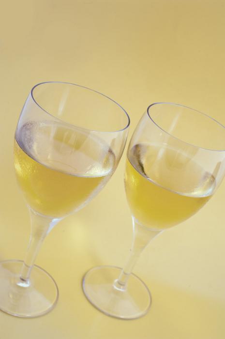 Free Stock Photo: Two glasses of white wine standing side by side, high angle view over a pale yellow background with copyspace