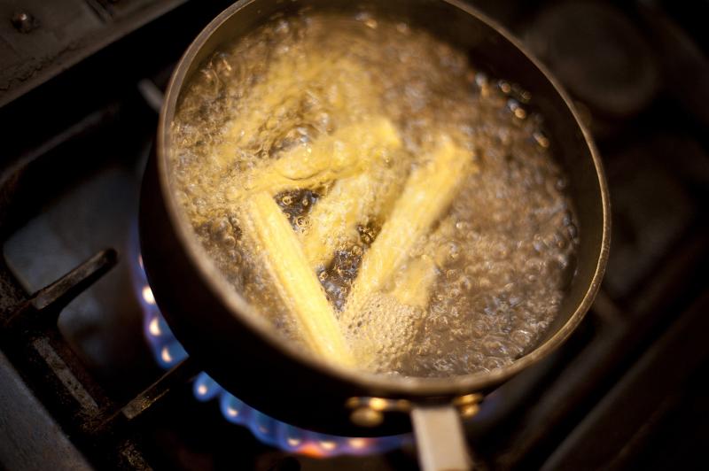 Free Stock Photo: Baby sweetcorn or corn on the cob boiling in a pot on a gas hob, view from above with lots of frothy bubbles