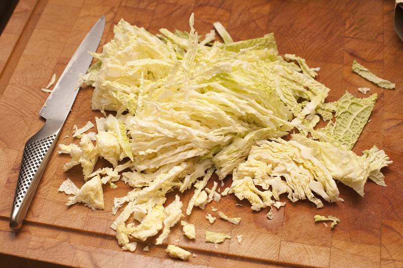 Free Stock Photo: Finely sliced fresh cabbage on a wooden chopping board in the kitchen ready to be used to make a healthy coleslaw salad or to be baked in the oven as a vegetable accompaniment