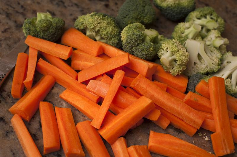 Free Stock Photo: Chopped fresh carrots and broccoli on a counter in a kitchen ready to be cooked for dinner , closeup background view