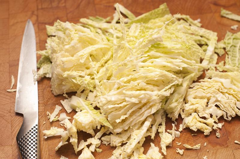 Free Stock Photo: Sliced raw cabbage on a chopping board with a sharp kitchen knife ready to be used in a coleslaw salad or cooked for a meal
