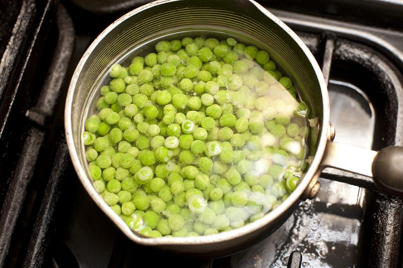 Free Stock Photo: Pot of fresh green peas on the hob standing in water waiting to be cooked and boiled as an accompaniment to a meal