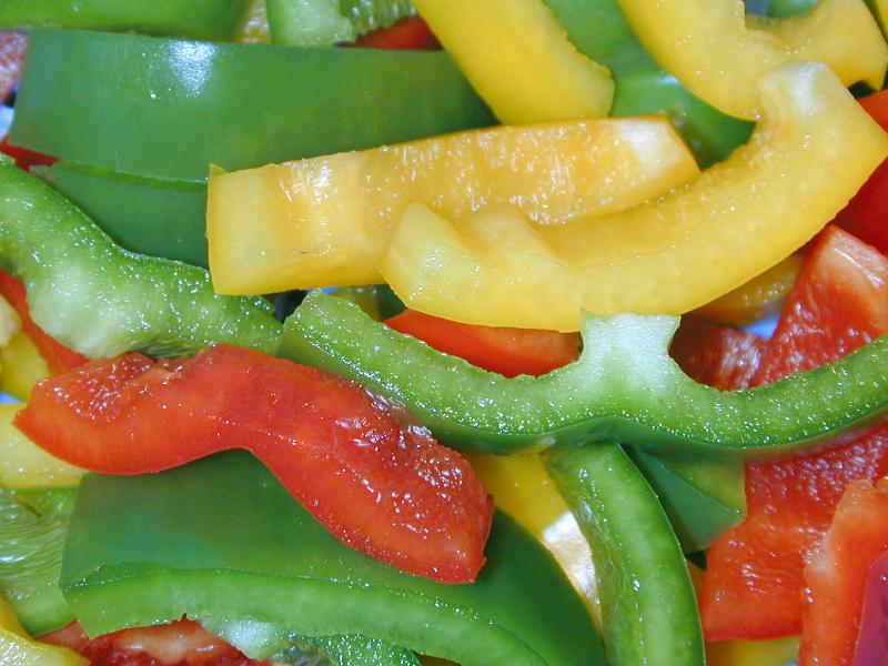 Free Stock Photo: Food or catering background of sliced colorful sweet bell peppers in green, red and orange for use in a healthy fresh salad or as a flavoring in cooking