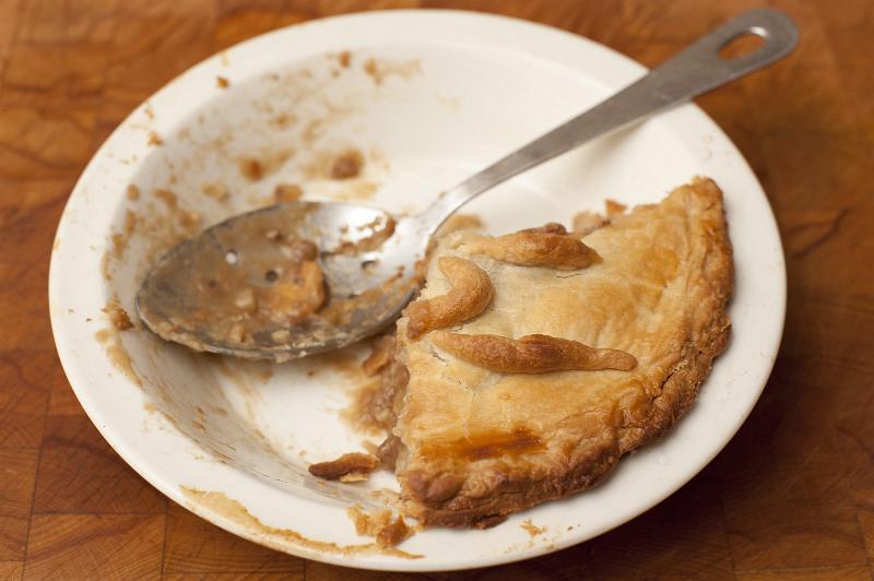 Free Stock Photo: Leftover portion of pie with a golden pastry crust in a plate with a spoon for serving, high angle close up view