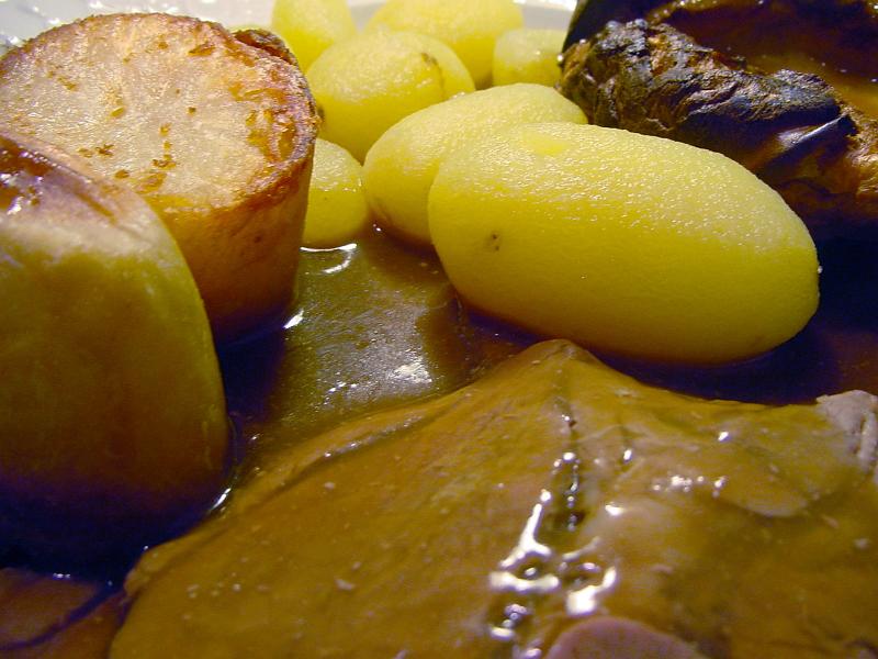Free Stock Photo: Close up of a serving of traditional English sliced roast beef, potato and Yorkshire Pudding topped with gravy
