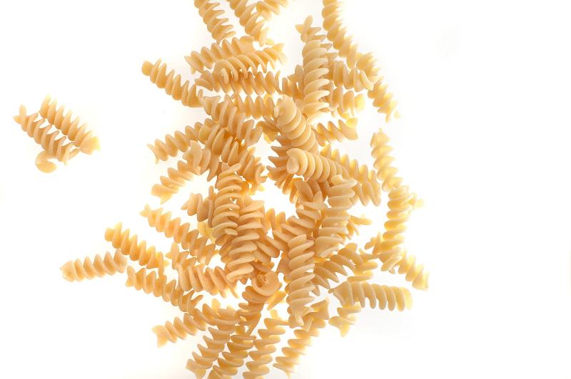 Free Stock Photo: Spiral twist uncooked dried Italian pasta scattered on a white background with copyspace viewed from above