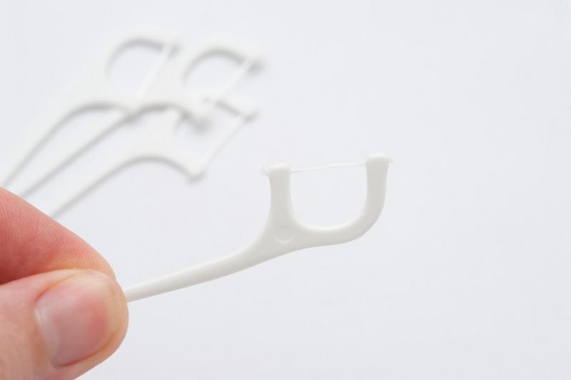Free Stock Photo: close up on a hand holding a dental flossing tooth pick