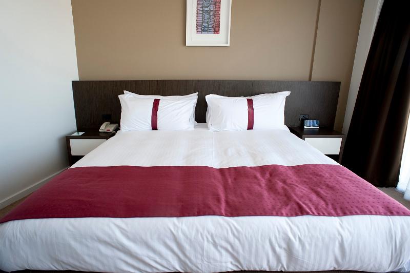 Free Stock Photo: Stylish king size bed with maroon highlights and a black headboard in a modern bedroom