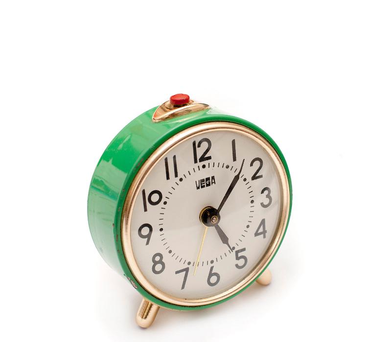 Free Stock Photo: Retro green alarm clock with a round dial and Arabic numerals and a small red button at the top to deactivate the ring on a white background
