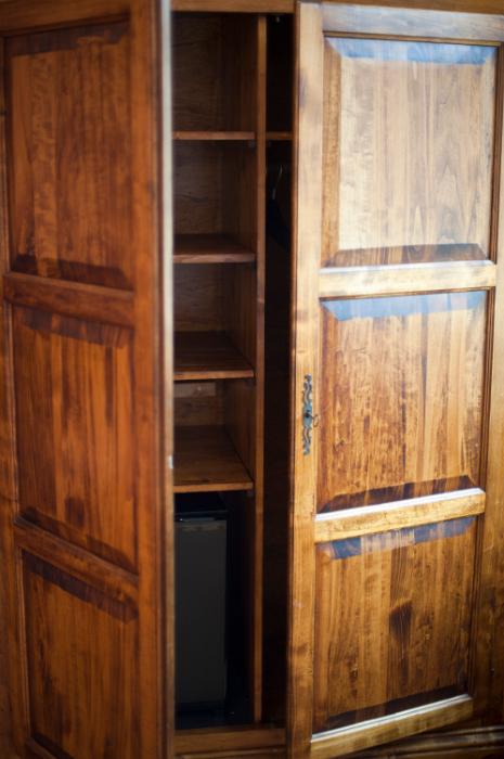 Free Stock Photo: Old rustic wooden wardrobe with the doors ajar to reveal empty shelves inside,close up view