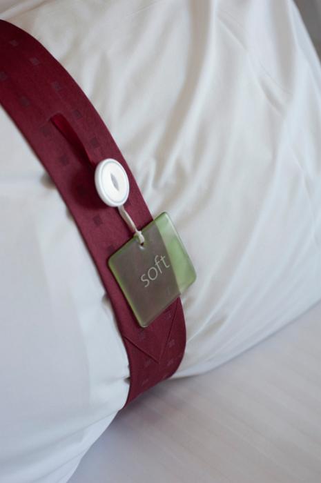Free Stock Photo: White pillow in an upmarket hotel bedroom with a decorative band tagged - Soft - on an attached label, close up view