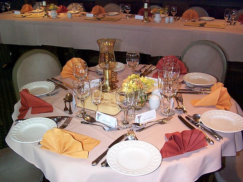 Free Stock Photo: Elegant dining table at a catered event set with six place settings with luxury linen, silverware , name cards and white plates