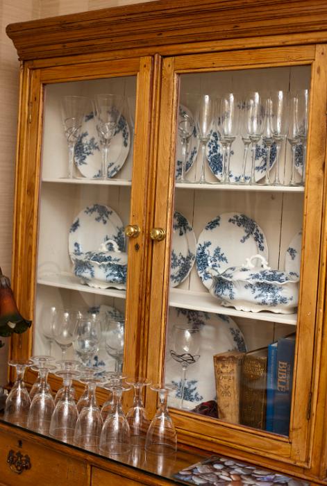 Free Stock Photo: Plates from a blue and white dinner service displayed in an old rustic glass fronted wooden dresser