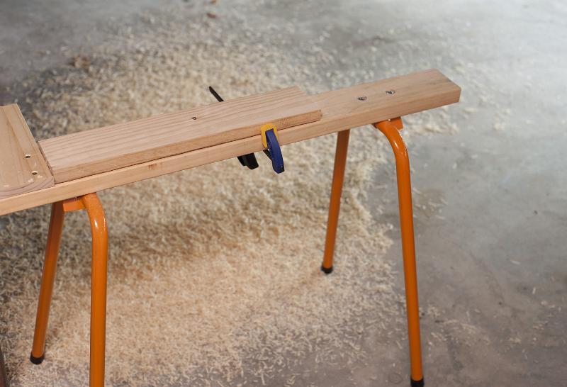 Free Stock Photo: Carpenters horse or narrow work bench allowing easy access to planks of wood on both sides while clamped, surrounded by wood shavings