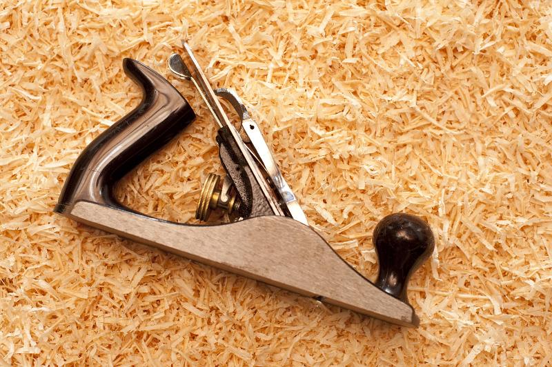 Free Stock Photo: Manual wood plane lying on fresh wood shavings in a carpentry or joinery workshop conceptual of DIY and a woodworking hobby