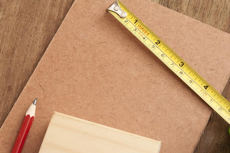 Free Stock Photo: DIY carpentry and woodworking concept with wood samples, a pencil and tape measure in inches and centimetres viewed from above